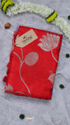 Red scarf with floral patterns on a gray fabric background