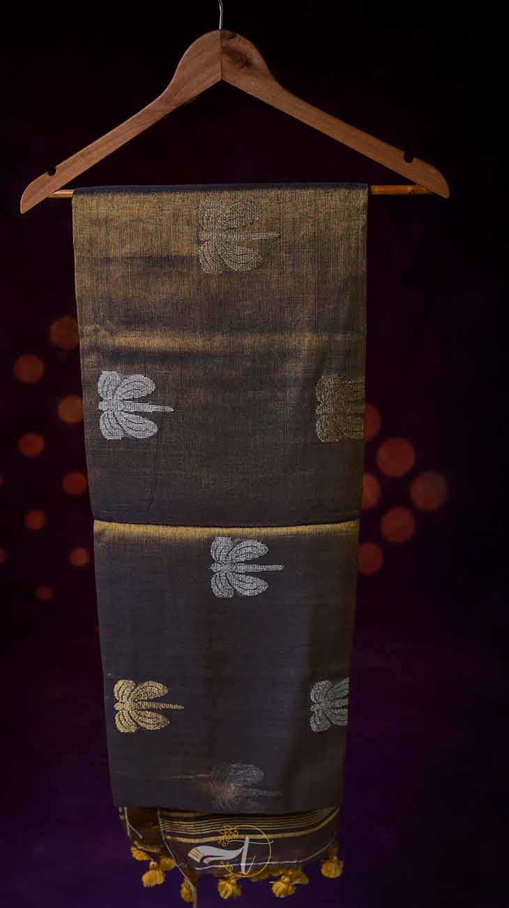 Dark fabric with embroidered patterns on a wooden hanger against a dark background