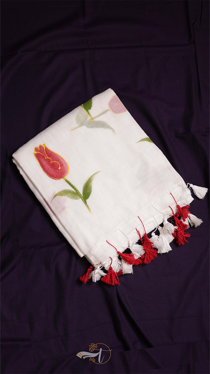 White fabric with floral embroidery and red tassels on a dark background