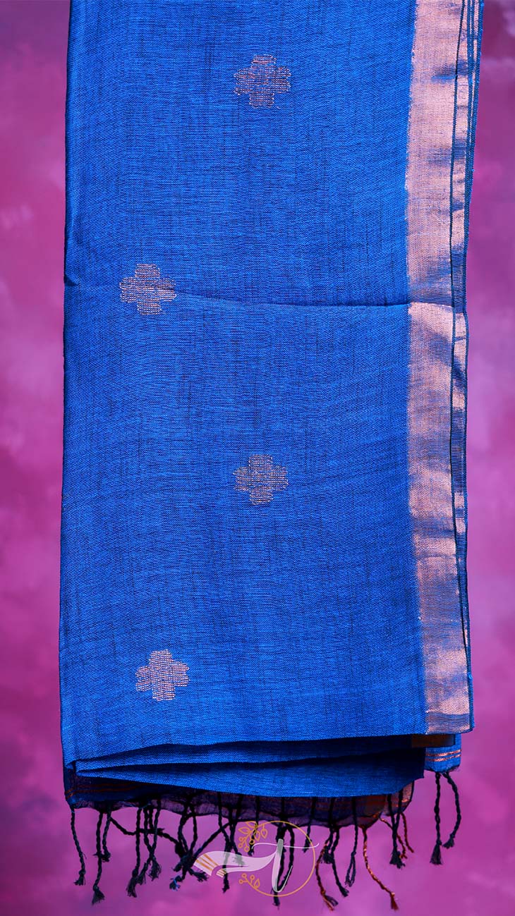 Blue fabric with white patterns and black fringes on a pink background