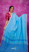 Woman wearing a blue saree with a pink background