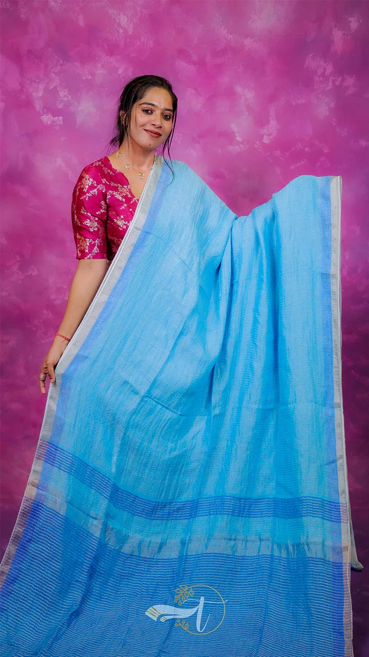 Woman wearing a blue saree with a pink background