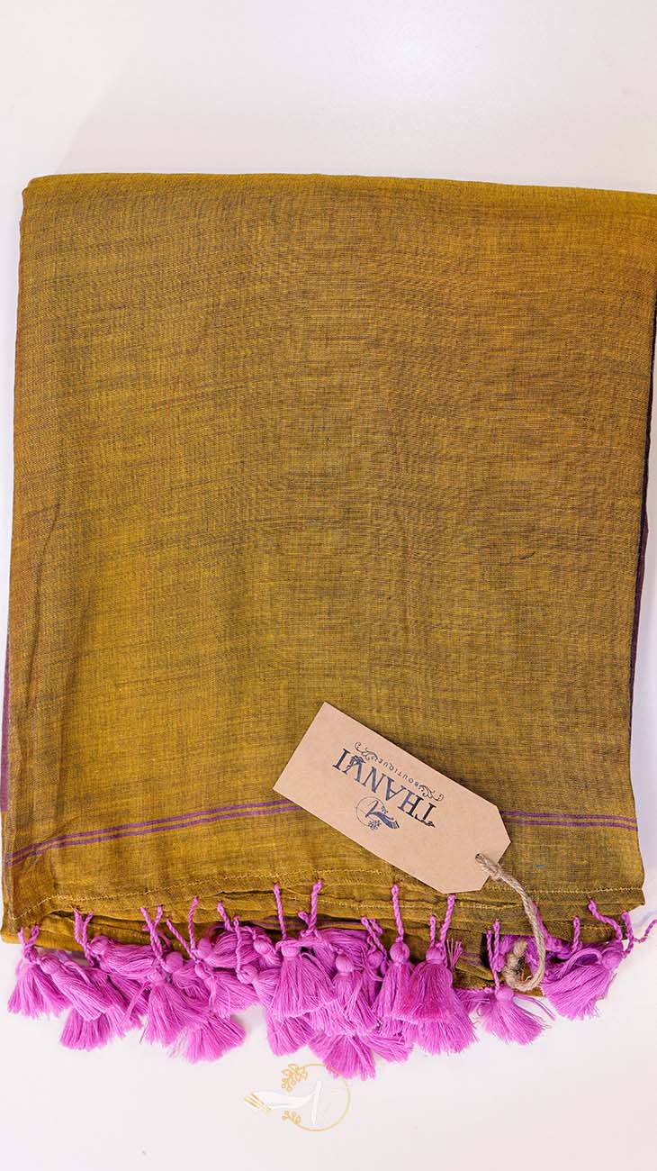 Mustard yellow towel with pink tassels and a visible brand tag on a white background