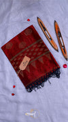 Red saree with black patterns on a light gray background