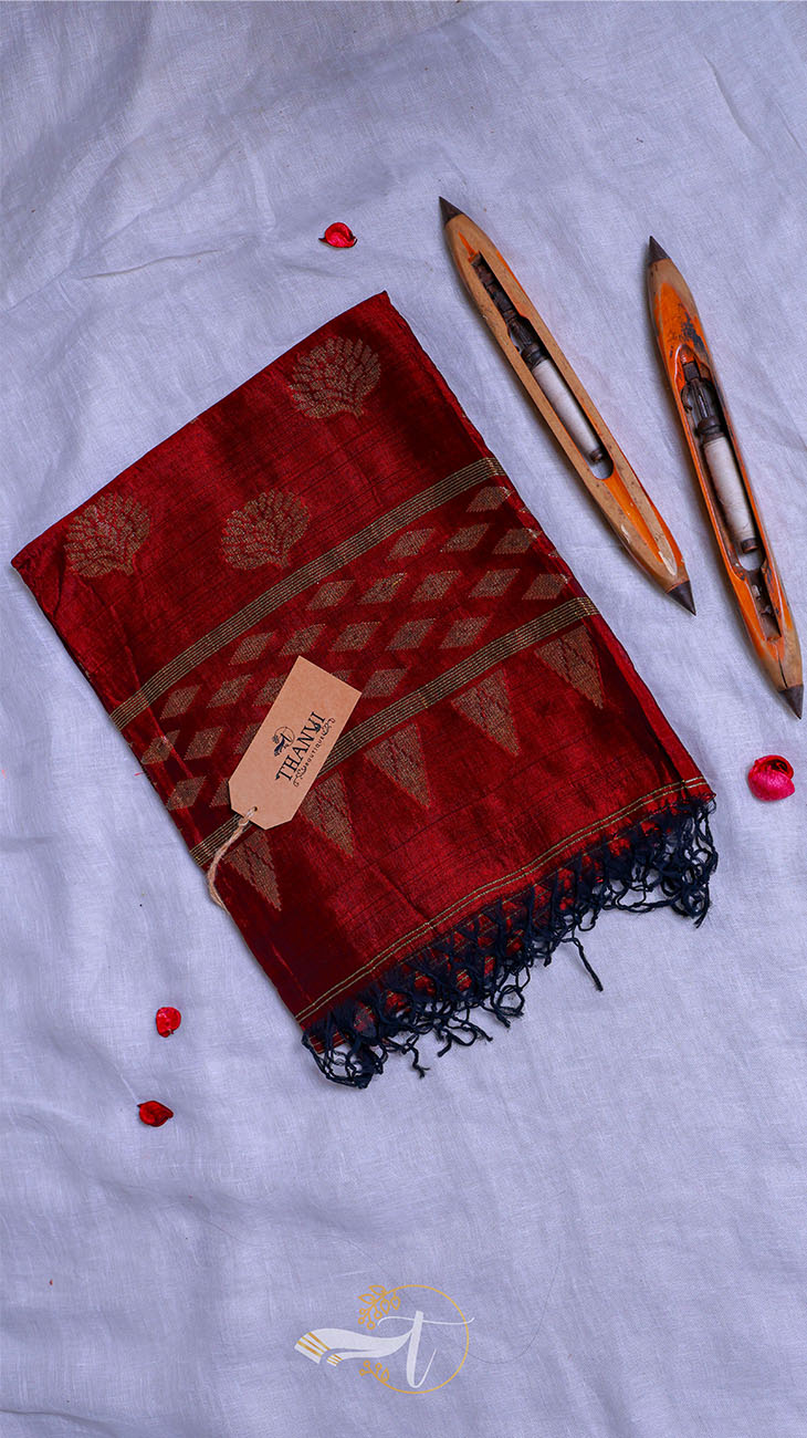 Red saree with black patterns on a light gray background