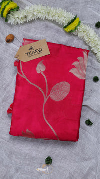 Red fabric with floral design and 'THANU' tag on a textured surface