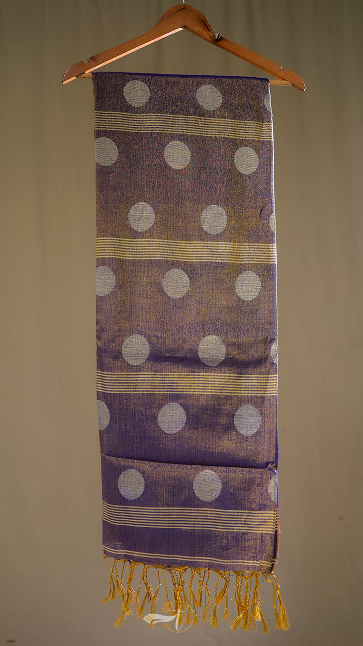 Purple scarf with white polka dots and gold fringe on a hanger against a beige background