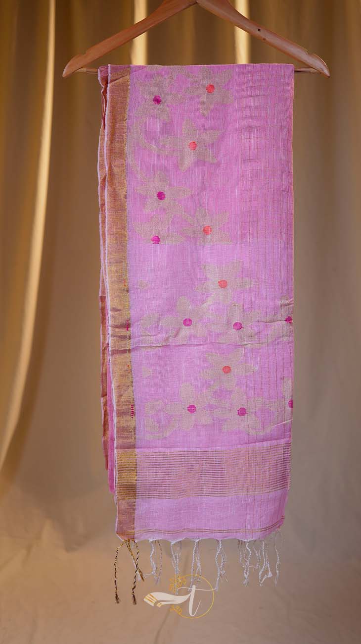 Pink scarf with floral patterns hanging on a wooden hanger against a beige curtain background
