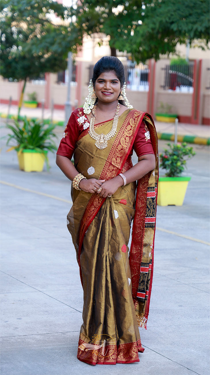 Woman in traditional saree with jewelry standing outdoors