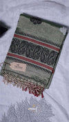 Green patterned scarf with tassels on a white surface, featuring a visible brand tag.
