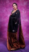 Woman wearing a black and brown saree against a purple background