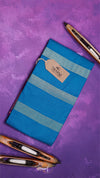 Blue notebook with striped design and a tag on a purple background