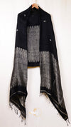 Black and gray patterned scarf on a hanger against a white background