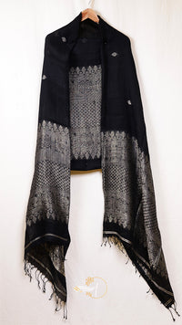Black and gray patterned scarf on a hanger against a white background