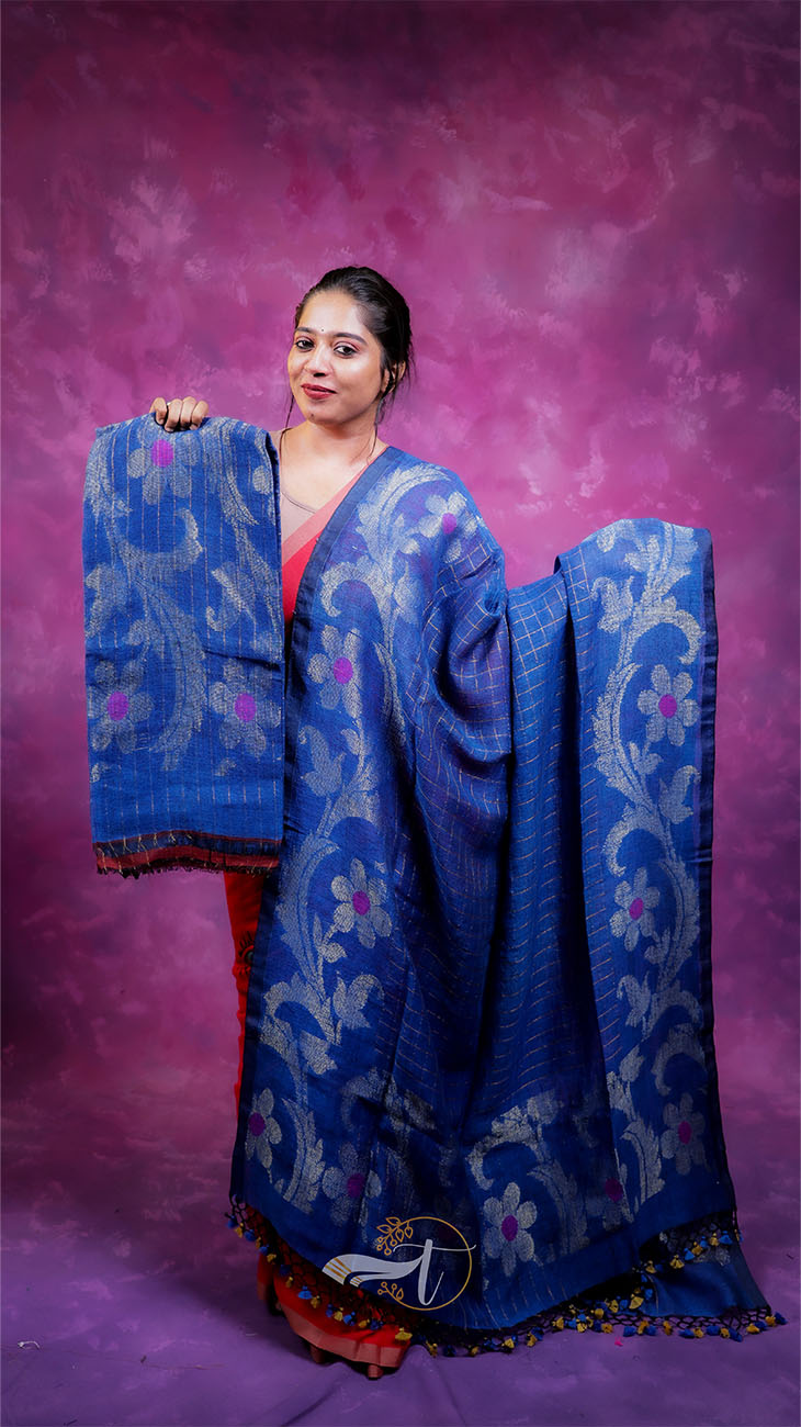 Woman holding a blue floral saree against a purple background