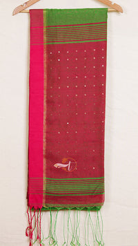Red and green saree with a white border on a wooden hanger against a white background