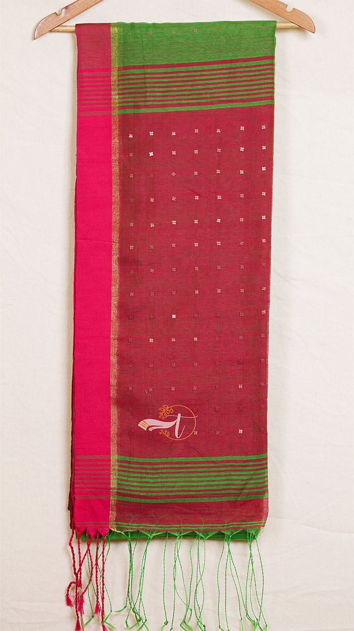 Red and green saree with a white border on a wooden hanger against a white background