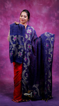Woman holding a blue and red saree against a purple background