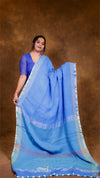 Woman wearing a blue saree with a brown background