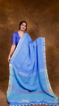 Woman wearing a blue saree with a brown background
