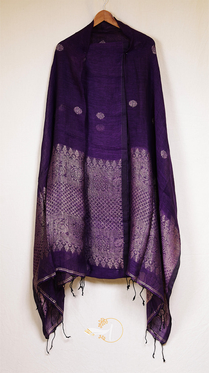 Purple shawl with intricate patterns draped over a wooden hanger on a white background