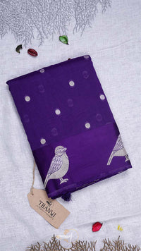 Purple fabric with bird patterns and a tag on a light gray background