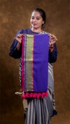 Woman holding a purple scarf with colorful patterns against a brown background