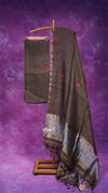 Brown saree with red buttons and a patterned border on a purple background