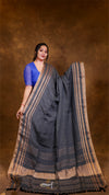 Woman wearing a dark blue saree with a brown background