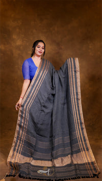 Woman wearing a dark blue saree with a brown background