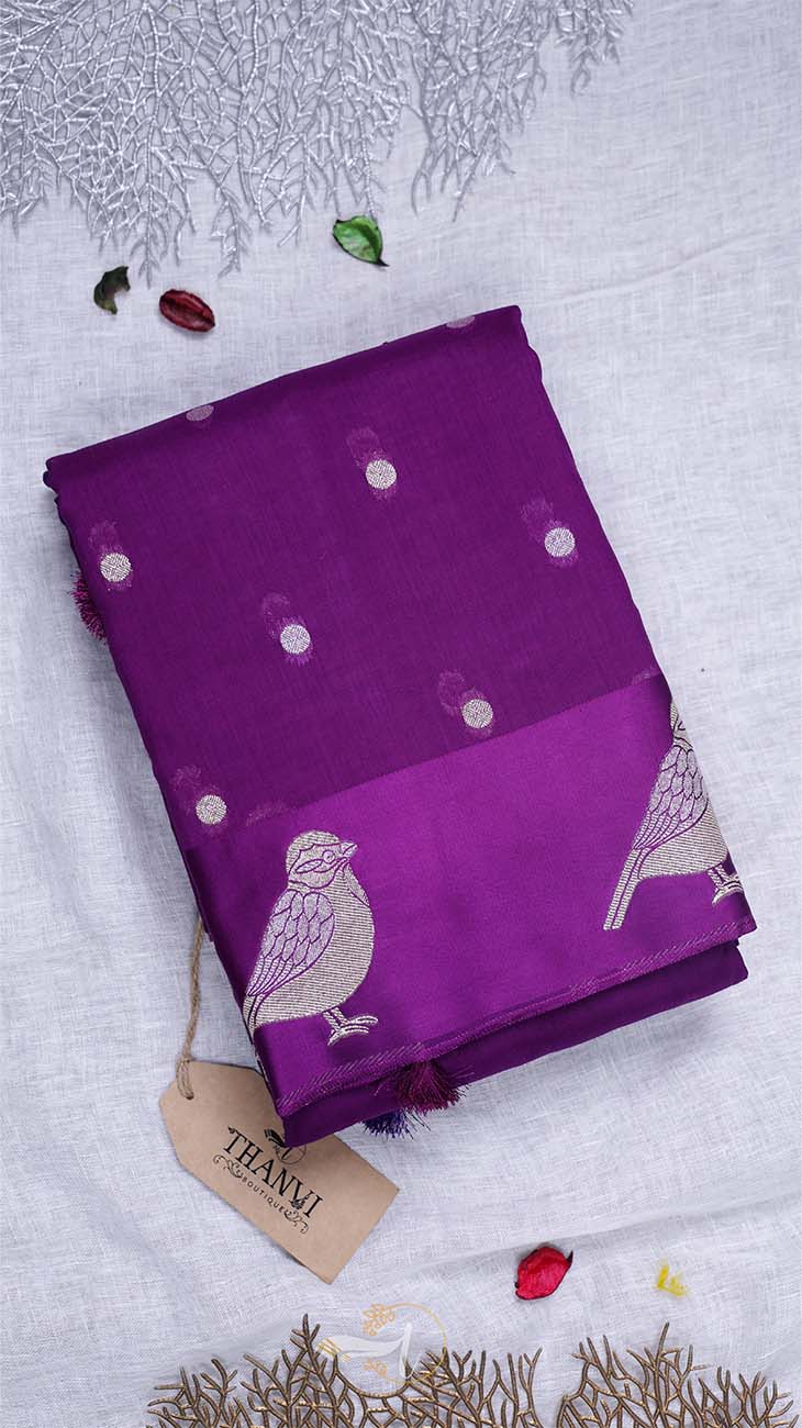 Purple fabric with bird patterns on a textured white background
