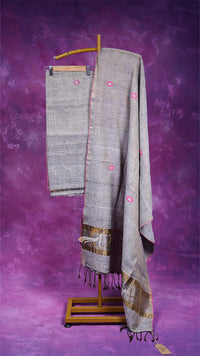 Gray saree with pink floral patterns on a wooden stand against a purple background