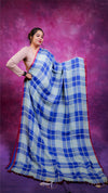 Woman wearing a blue and white checkered saree against a purple background