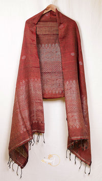 Red patterned scarf with tassels on a wooden hanger against a white background