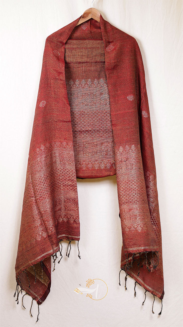 Red patterned scarf with tassels on a wooden hanger against a white background