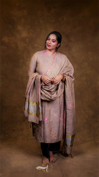 Woman wearing a traditional outfit with a shawl against a brown background