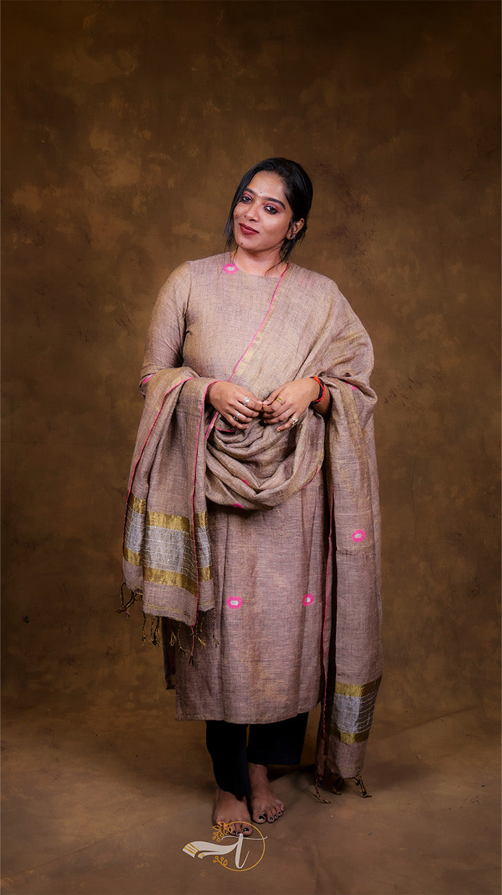 Woman wearing a traditional outfit with a shawl against a brown background