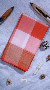 Red and white checkered fabric on a light gray surface with decorative items.