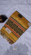 Yellow patterned scarf with a brand tag on a light gray fabric background