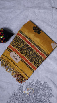 Yellow patterned scarf with a brand tag on a light gray fabric background