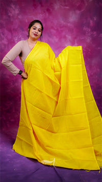 Woman holding a yellow saree against a purple background