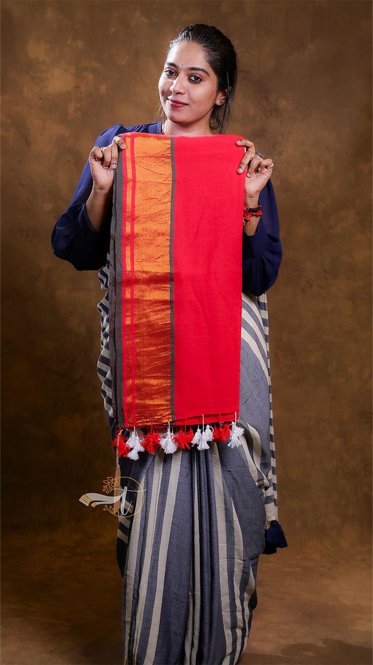 Woman holding a red and orange scarf against a brown background