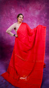 Woman wearing a red saree with a purple background