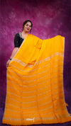 Woman holding a yellow saree with a purple background