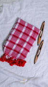 Red and white checkered towel with tassels on a light gray background