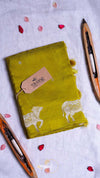 Green notebook with cow design and 'THAM' tag on a light background