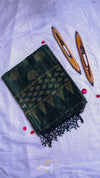 Green and black patterned fabric with wooden weaving tools on a white background