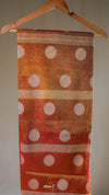 Textile with polka dot pattern on a hanger against a neutral background