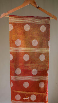 Textile with polka dot pattern on a hanger against a neutral background