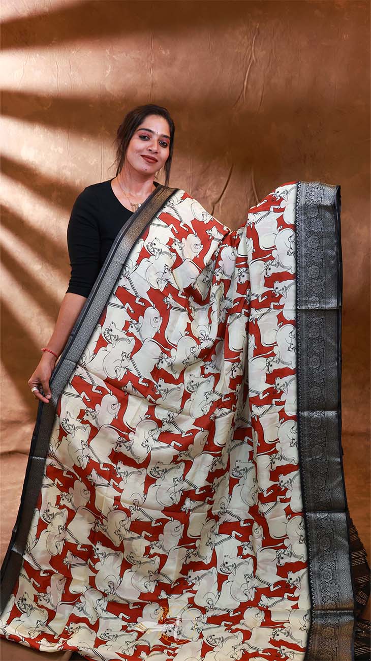 Woman wearing a saree with a red and white pattern against a brown background